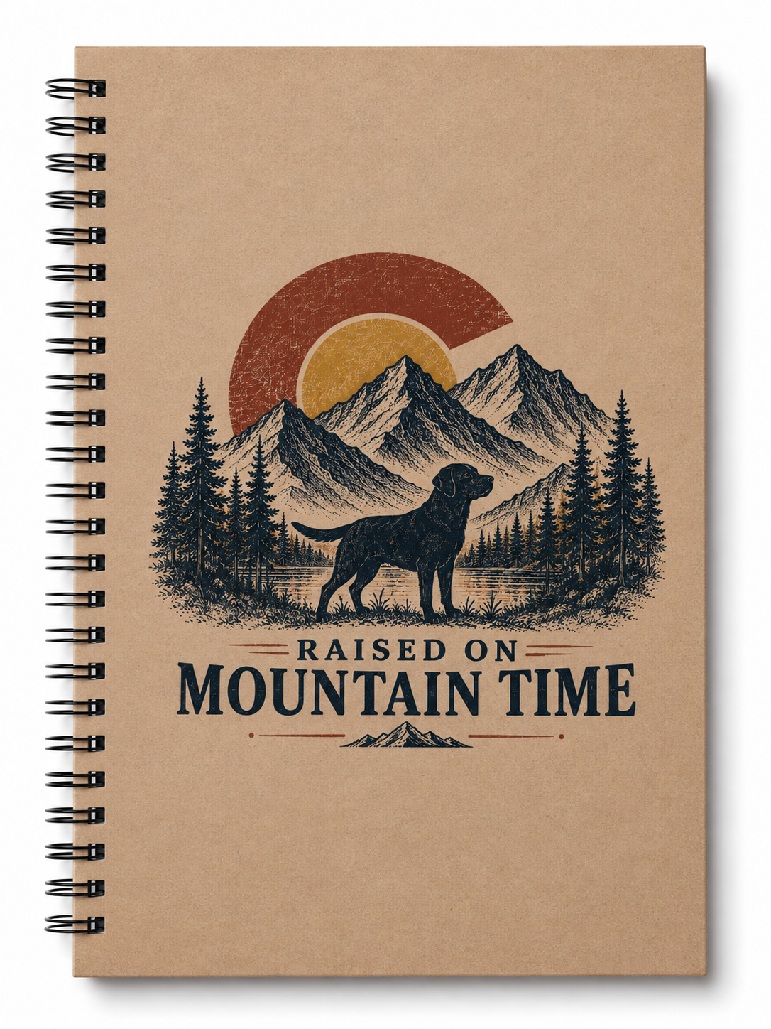 A spiral-bound notebook with a kraft paper cover featuring a mountain landscape illustration, a dog silhouette, pine trees, and the text 'RAISED ON MOUNTAIN TIME'.