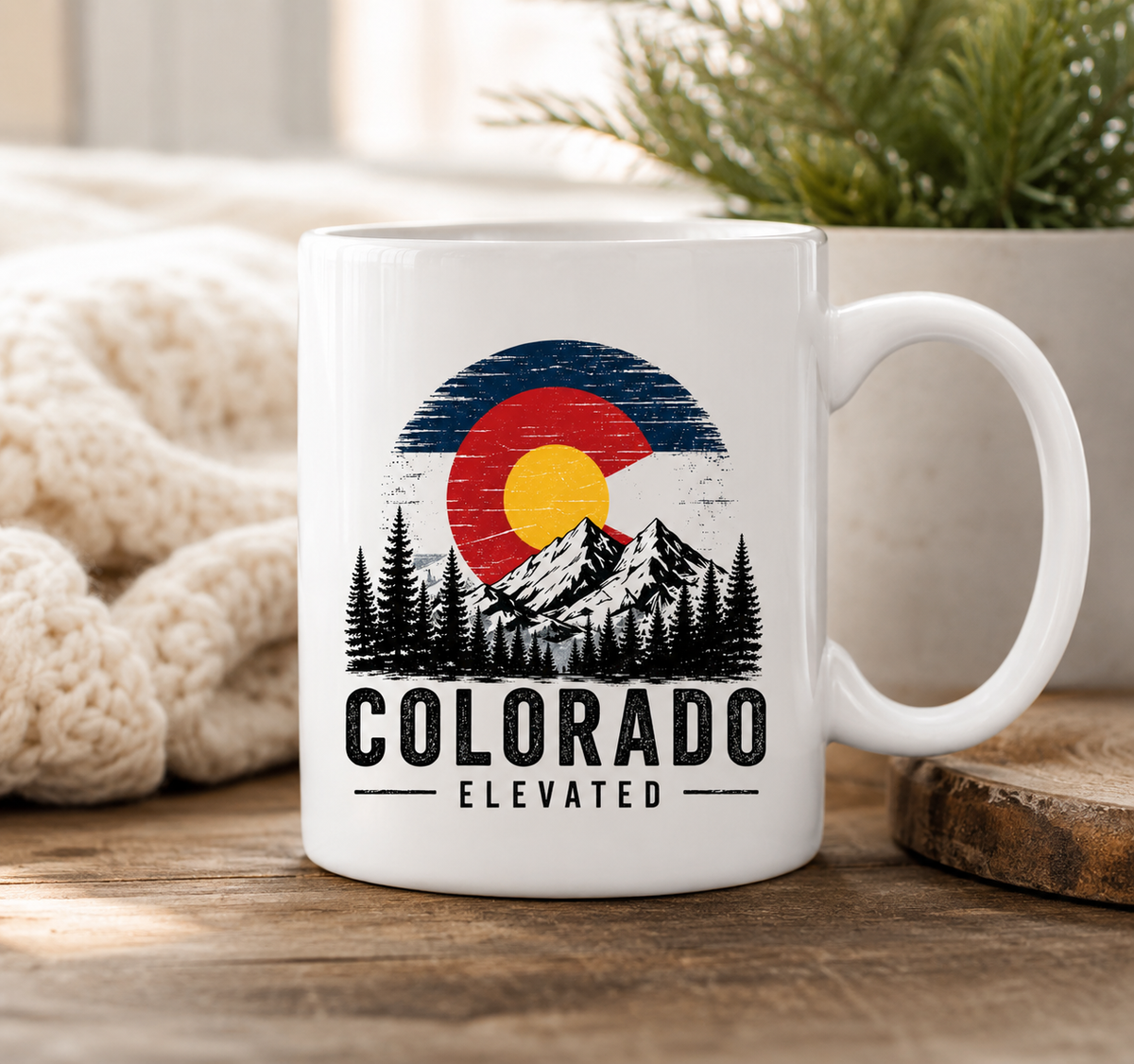 White 15 ounce ceramic Colorado Elevated mug with mountain, trees, and Colorado flag-inspired design