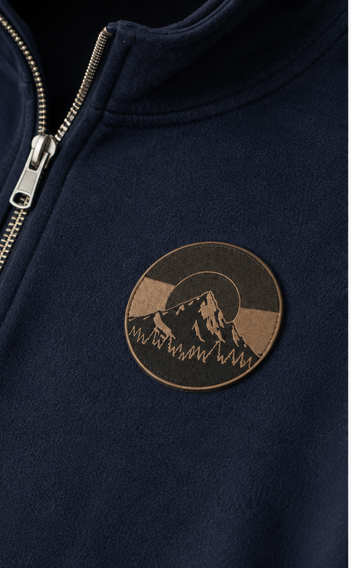 Close-up of embossed leather mountain patch on Colorado Mountain Quarter-Zip Pullover in navy